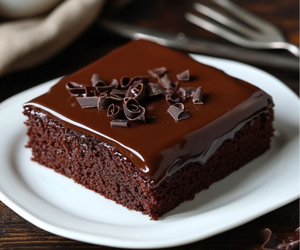 Iced chocolate sheet cake with a glossy glaze and chocolate curls